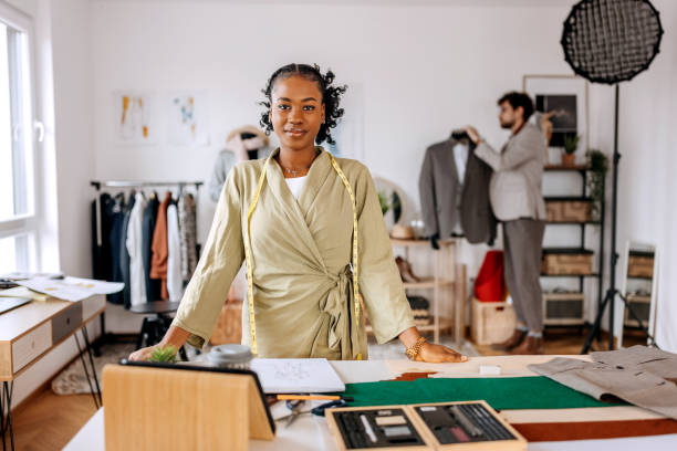A girl posing in front of the camera in her fashion designing classroom